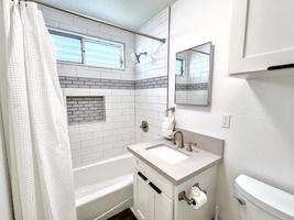 The guest cottage full bath features a shower/tub combo and modern finishes for a comfortable stay.