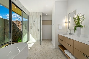 Unwind in your spa-inspired bathroom with soaking tub, rainfall shower, and natural light streaming through garden views.