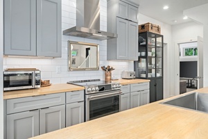Effortless and functional—cook and connect in this clean-lined kitchen with modern appliances and open shelving.