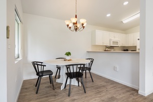 Your bright dining space features elegant lighting and connects seamlessly to a fully equipped kitchen, perfect for memorable meals together.