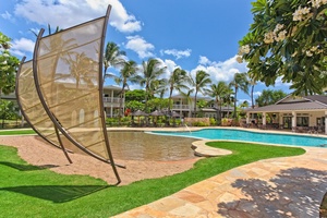 Tropical resort pool area with palm trees and modern amenities under sunny Hawaiian skies.