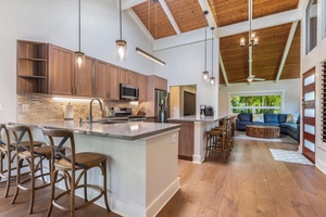 Lani Oasis’ chef-ready kitchen includes stainless steel appliances, a large island with bar seating, and open flow to dining and living spaces.