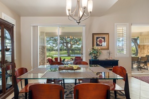 Gather around this elegant glass dining table where natural light streams through windows, creating the perfect space for memorable meals together.