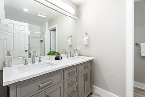 Modern primary bathroom with dual sinks, sleek fixtures, and ample vanity storage.