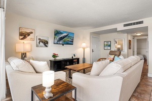 Sink into plush sofas while ocean-inspired art surrounds you in this bright, welcoming space perfect for relaxing together.