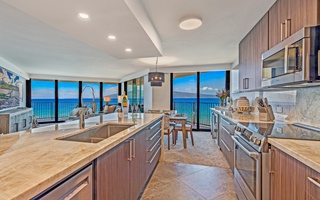 Kaanapali Shores 702’s kitchen features modern appliances, island seating, and ocean views.