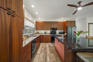 The chef's kitchen features granite countertops, wraparound cabinetry, and modern appliances for effortless cooking.