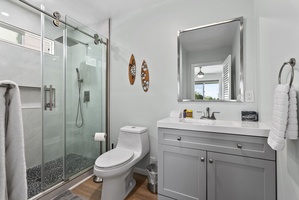 This modern bathroom combines elegance and functionality, featuring a spacious vanity and sleek glass shower.