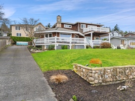 A charming water view property with expansive deck and lush lawn, nestled in a peaceful residential neighborhood.