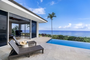 Modern tropical villa with infinity pool and stunning ocean views surrounded by lush greenery.