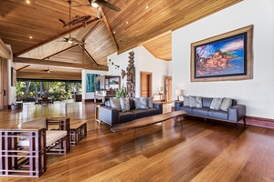 Relax in your spacious tropical living room featuring soaring wood ceilings, polished floors, and comfortable seating where you'll unwind after island adventures.