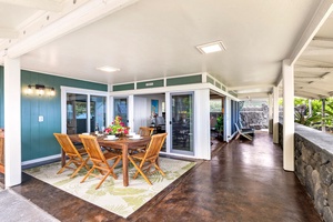 Covered lanai with shaded seating, perfect for family meals or games outdoors.