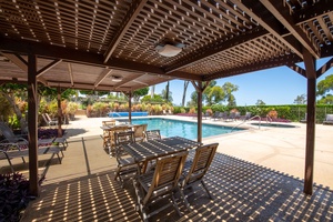 Dine in comfort under the pergola at Cabana A, where shaded tables offer the perfect spot to gather and relax poolside.