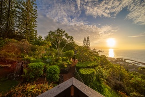 Stunning coastal property surrounded by lush tropical gardens, offering spectacular sunset views over the ocean horizon.