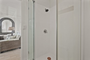 Step into your pristine glass-enclosed shower with modern fixtures and refreshing rainfall showerhead for a luxurious cleansing experience.