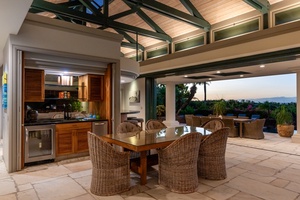 Indoor-outdoor dining area with comfortable wicker chairs and stunning views.