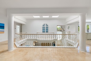Open-air atrium with skylights and balcony views creates a bright and peaceful upstairs landing.