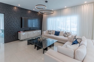 The living area has plush furnishings and large TV, perfect for unwinding.