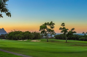 Bali Hai, ocean, and green fairways glow beneath a Kauai sunset — a perfect setting to end each day.