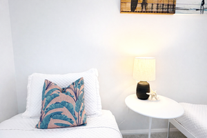 Drift into peaceful slumber surrounded by soft white linens, tropical-inspired pillows, and gentle lamplight creating your perfect bedtime sanctuary.