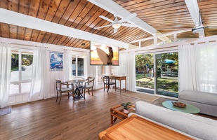 Relax in your open-concept living space with soaring wood beam ceilings and floor-to-ceiling windows flooding the room with natural light.