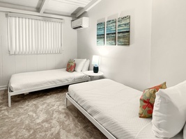 Connected bedrooms with twin beds, accessible through the attached first bedroom.