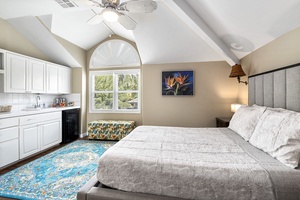 Guest suite with king bed, vaulted ceilings, central A/C, and private kitchenette access.