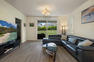 Relax in your spacious living room with premium leather seating and garden views through sliding doors.