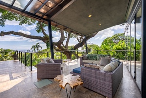 Stylish loft-style seating area with contemporary design and lush greenery views.