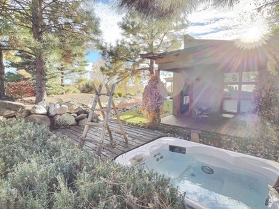 The sweet hot tub nestled in the trees with views of the mountains and privacy fence with private deck