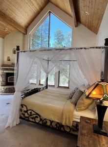 King bedroom with draped fairy tale bed and huge views