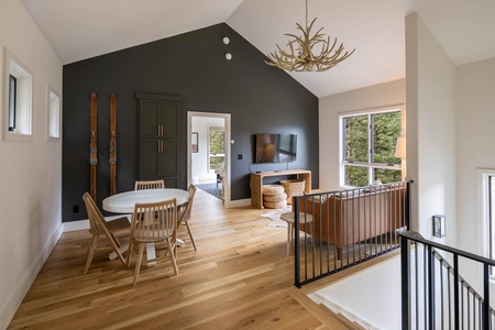 The upper lounge area with cafe work table, smart TV and comfy seating in a light-filled space.