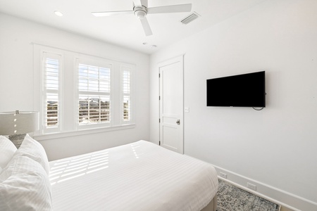Wake up in your serene bedroom sanctuary, where crisp white linens meet modern comfort and natural light streams through elegant shutters.