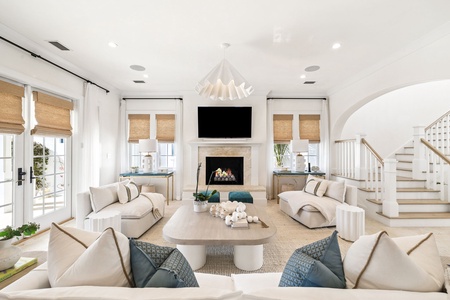 Unwind in your elegant living room where plush seating circles a cozy fireplace, perfect for intimate evenings together.