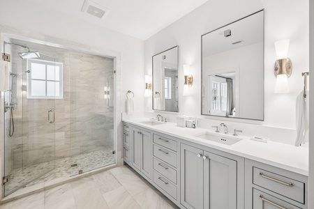 Step into your private spa-like sanctuary, featuring a spacious walk-in shower, dual vanities with elegant marble countertops, and modern fixtures that blend comfort with style.