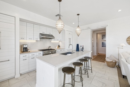 Step into your dream kitchen where elegant pendant lights illuminate pristine white countertops, perfect for morning coffee or evening wine.