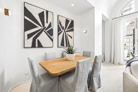 Gather around this inviting dining table for shared meals and conversation. Light streams through elegant windows, highlighting the space's clean design and cozy vibe—perfect for your group's time together.