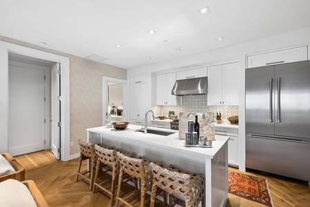 Bright, chef-ready kitchen featuring a spacious island, premium stainless appliances, and crisp white cabinetry—perfect for culinary adventures and gathering.