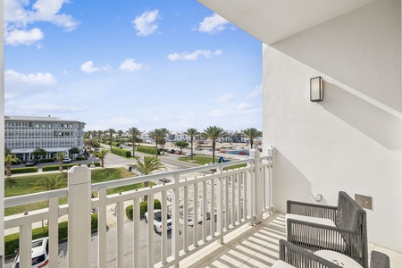 Spacious balcony overlooking manicured resort grounds with comfortable seating for morning coffee or sunset relaxation.