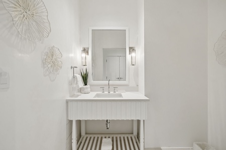 Relax in this serene, spa-like bathroom featuring a coastal-inspired vanity with elegant fixtures, soft lighting, and artistic touches that make your daily routine feel like a luxury escape.