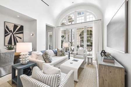 Sink into plush seating in your bright, airy living space, where grand arched windows frame natural light and elegant design details create the perfect setting for your relaxation.