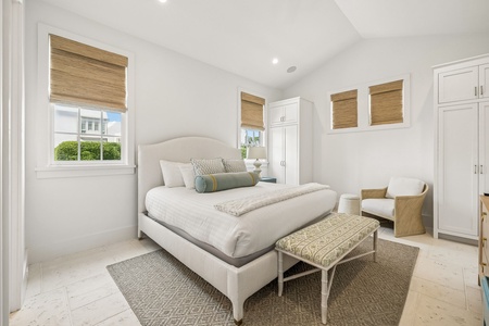 Sink into the plush bed and let natural light pour through bamboo shades. Your serene retreat features thoughtful touches like a cozy reading chair and ample storage space for total relaxation.