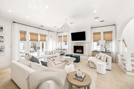 Sink into plush sofas by your cozy fireplace, where natural light streams through bamboo shades and elegant touches create your perfect retreat.