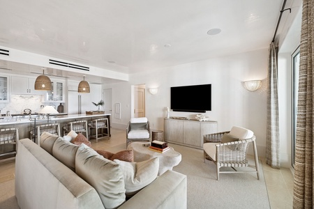 Relax in your sophisticated living space with plush seating, modern kitchen, and coastal-inspired design perfect for memorable gatherings.