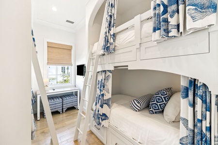 Your bunk room feels like a nautical dream with crisp blue-and-white linens and cozy reading nooks by the window.
