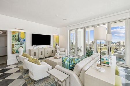 Unwind in your elegant living space with plush seating, modern art, and seamless access to your private balcony for ultimate relaxation.