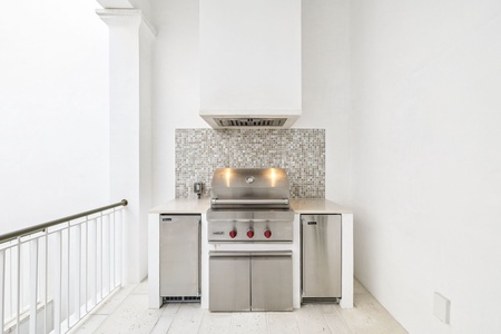 Your private outdoor kitchen features professional-grade stainless steel appliances and elegant mosaic tile backsplash for memorable grilling experiences.