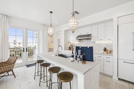 Your gourmet kitchen awaits with pristine white cabinets, elegant pendant lights, and a spacious island perfect for morning coffee or evening wine.
