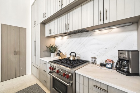 Your fully-equipped kitchen makes home cooking a breeze with a professional gas range, sleek marble backsplash, and everything you need to brew your morning coffee in style.