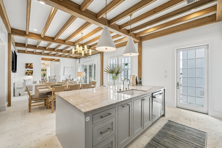 You'll love the soaring wood-beamed ceilings and bright open layout, where the kitchen flows seamlessly into the dining and living spaces—perfect for gathering with loved ones.